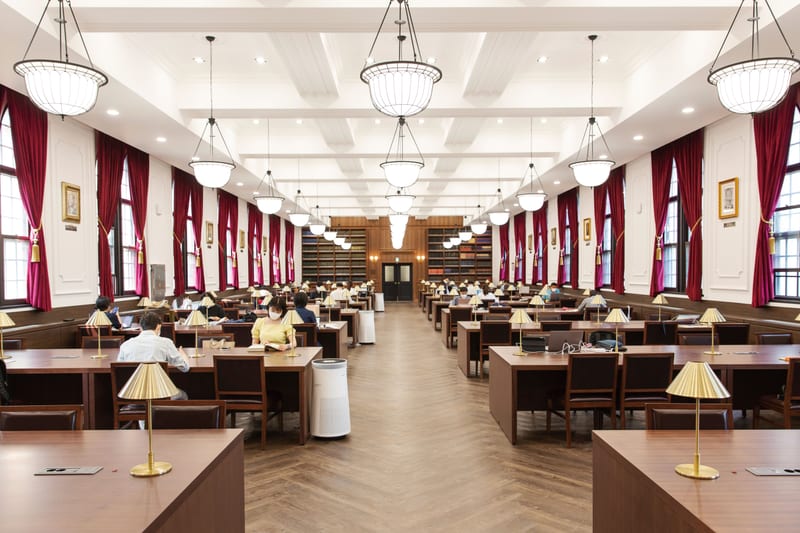 Korea University reading room with crimson curtains, chandeliers, and rows of wooden study desks.