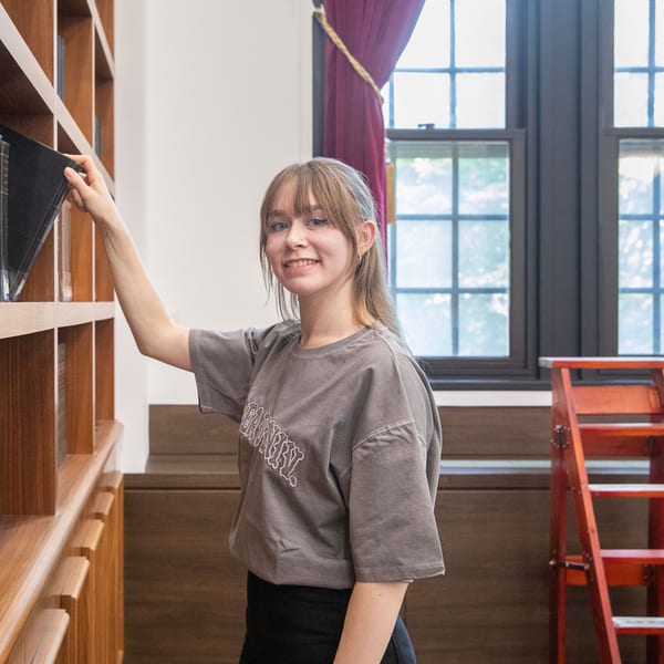Olivia Fries, an international student from Germany, smiles by the bookshelves of Korea University's Centennial Memorial Library.